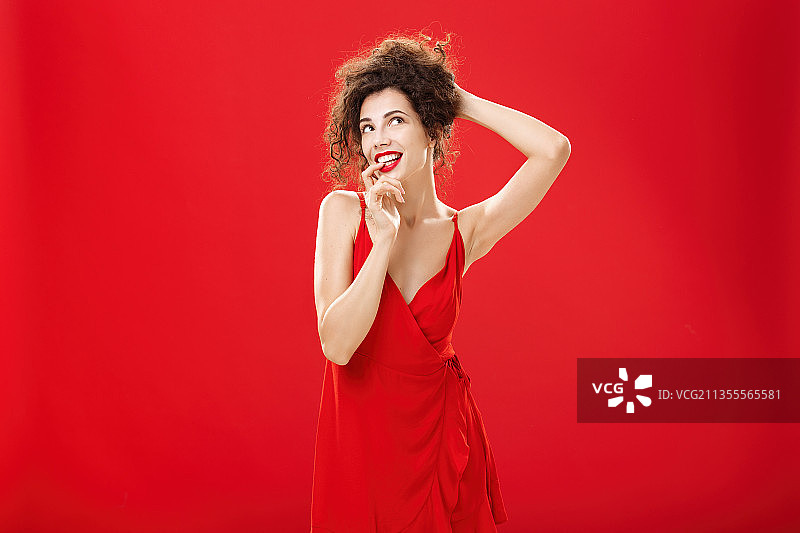 站在红色背景前比出和平手势的女性肖像图片素材