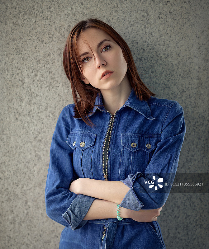 年轻女子站在墙前的肖像图片素材