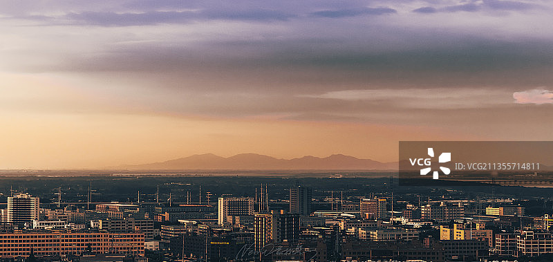 夕阳下的城市天际线以及山脉风光图片素材
