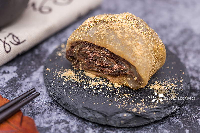 在紫砂壶和书法的中国风背景前有一盘中式小吃驴打滚图片素材