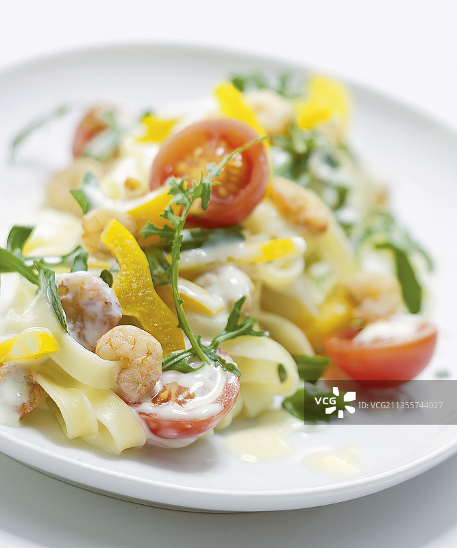 奶油芝士虾仁意面配黄椒、番茄和芝麻菜图片素材