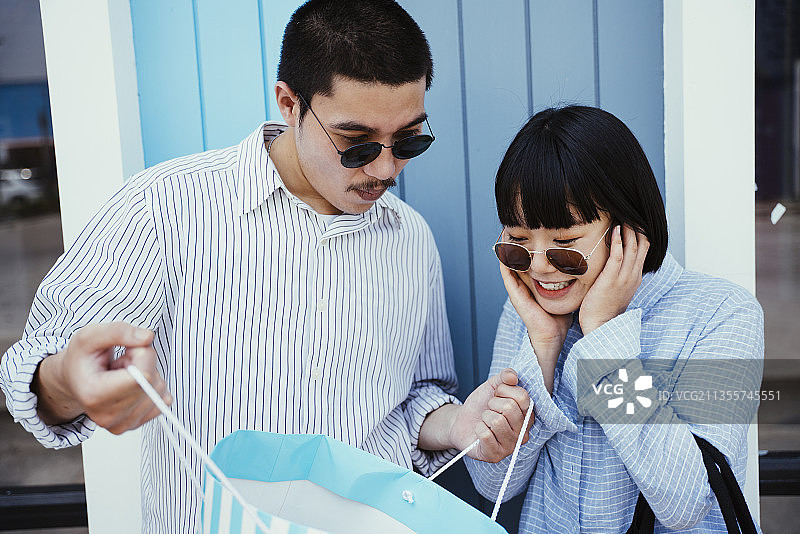 光头党给女朋友买礼物，给她一个惊喜。男人给女朋友买礼物。图片素材