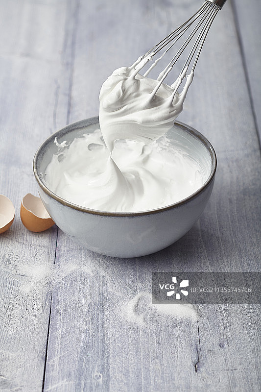 碗中和搅拌器上的打发蛋白（蛋白酥皮）图片素材