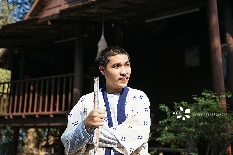 生态旅游-一名当地农民在乡村地区拿着铲子摆造型。图片素材