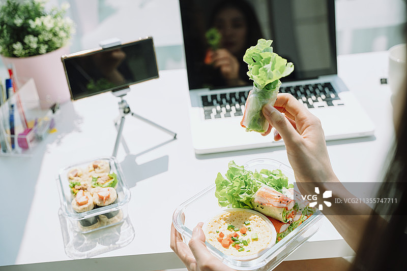 在社交媒体上上传健康食品视频。女性推荐健康食品。图片素材