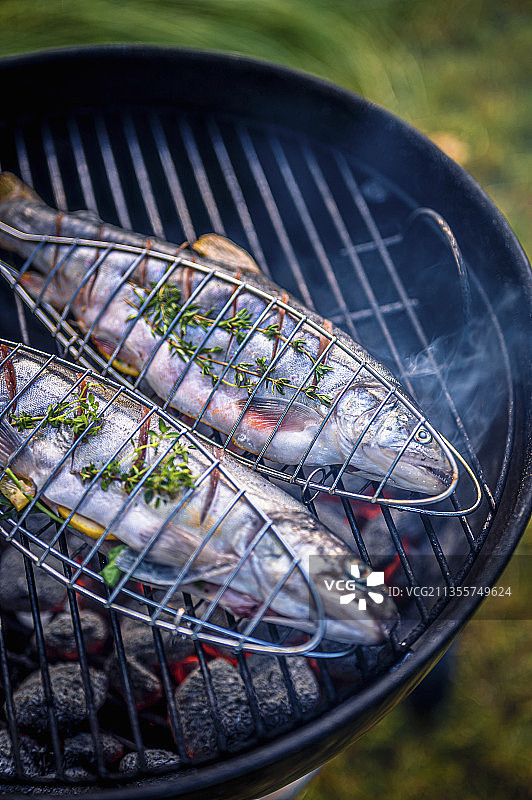 烤鱼篮烤鳟鱼配柠檬香草图片素材