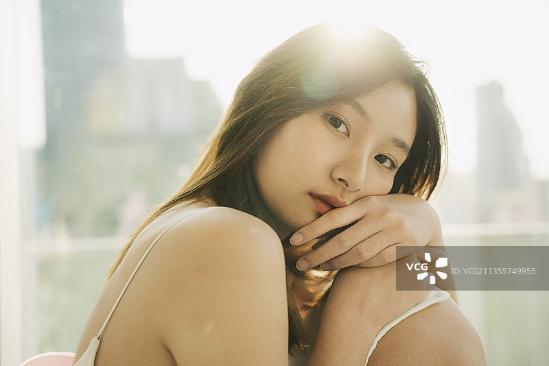 时尚肖像-年轻的亚洲泰国日本女人在房间里性感的白色衬衫。摩天大楼的背景。图片素材