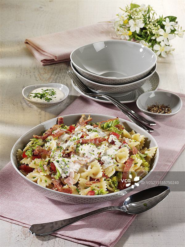 蝴蝶面沙拉配罗马生菜、番茄、火腿和酸奶酱图片素材