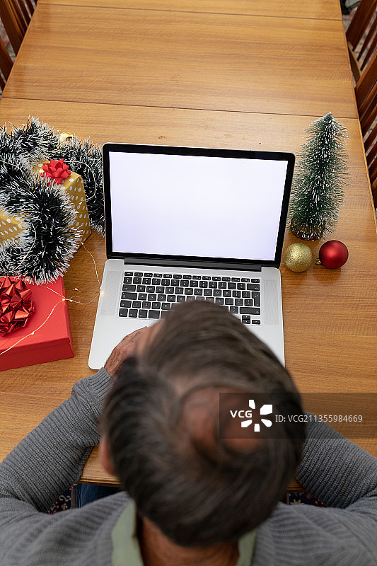 圣诞节期间，年长的白人男子在笔记本电脑上进行视频通话图片素材