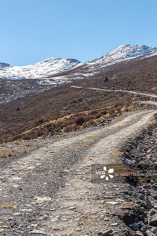 高原雪山森林中的越野道路图片素材