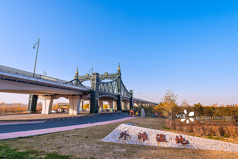 秋季哈尔滨松花江外滩湿地公园的树林建筑道路图片素材