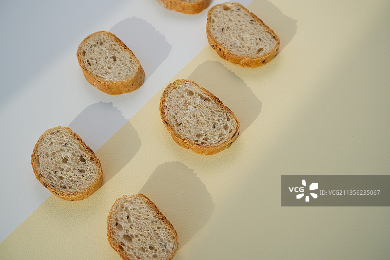 6个自制的有机切片面包，背景为黄色和白色。图片素材