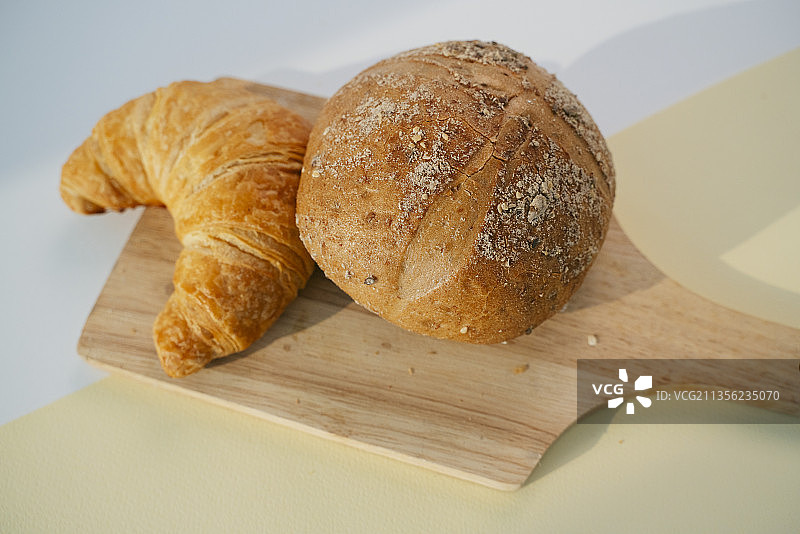 全麦面包和木制垫上的金色十字路口。图片素材