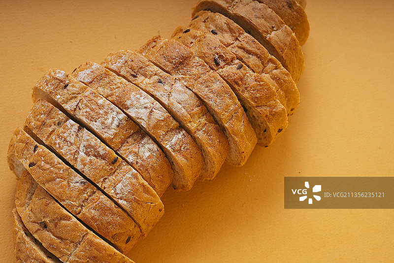 俯视图-面包切片橘色背景。图片素材