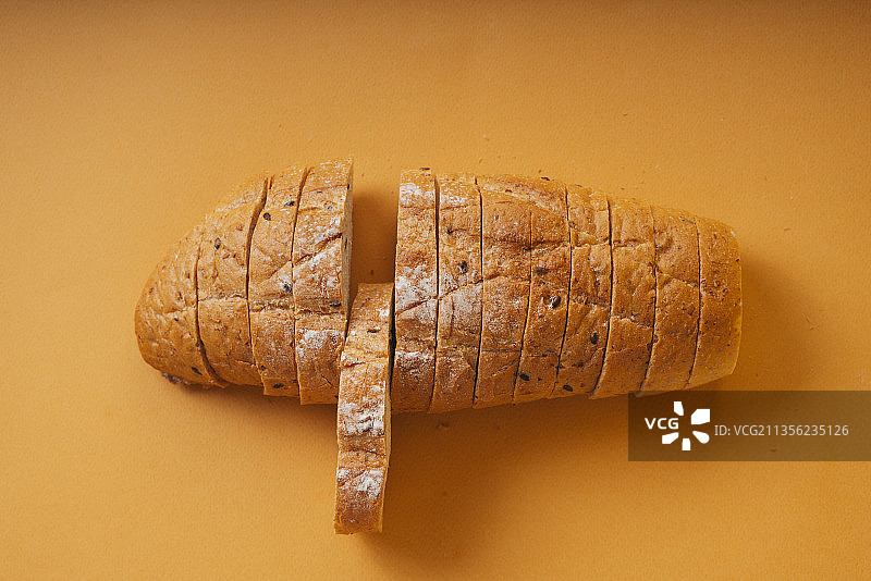 俯视图-面包切片橘色背景。图片素材