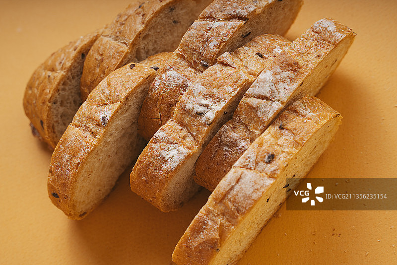 俯视图-面包切片橘色背景。图片素材