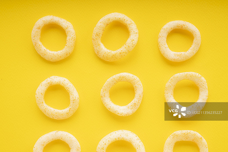 俯视图-黄色背景上脆圆洋葱圈。图片素材