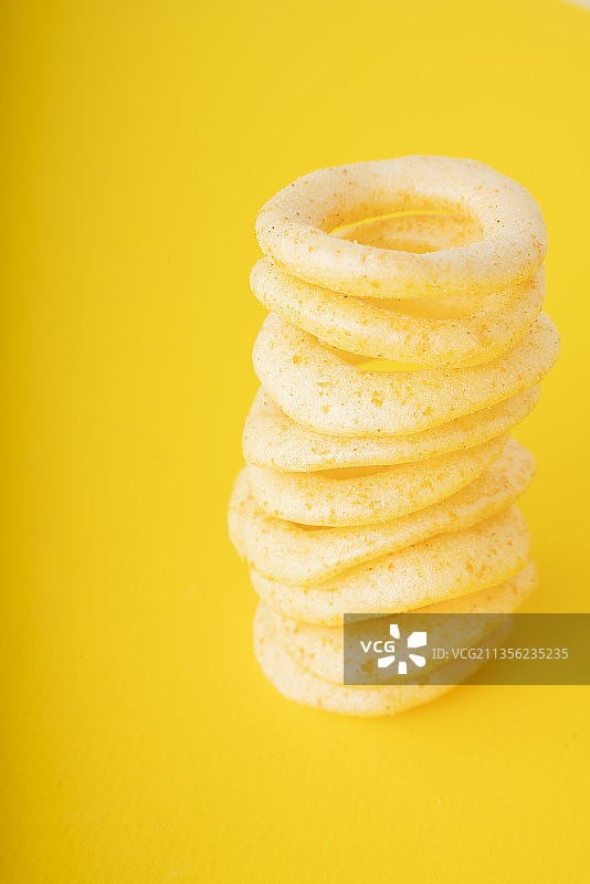 黄色背景上的脆洋葱圈。图片素材