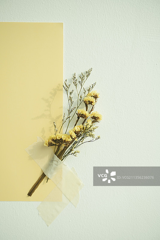 在黄色的背景上模拟黄色的纸和花束。副本的空间。图片素材