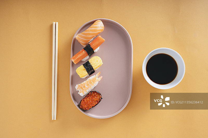 俯视图-日本寿司盘上有酱油和筷子。图片素材