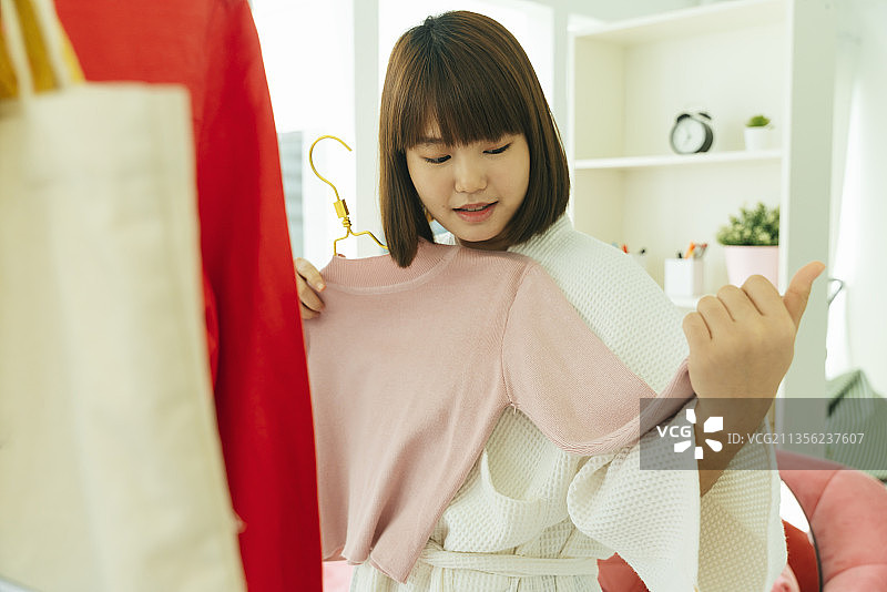 漂亮的年轻亚洲泰国黑色短发女人在浴衣寻找布料穿。图片素材