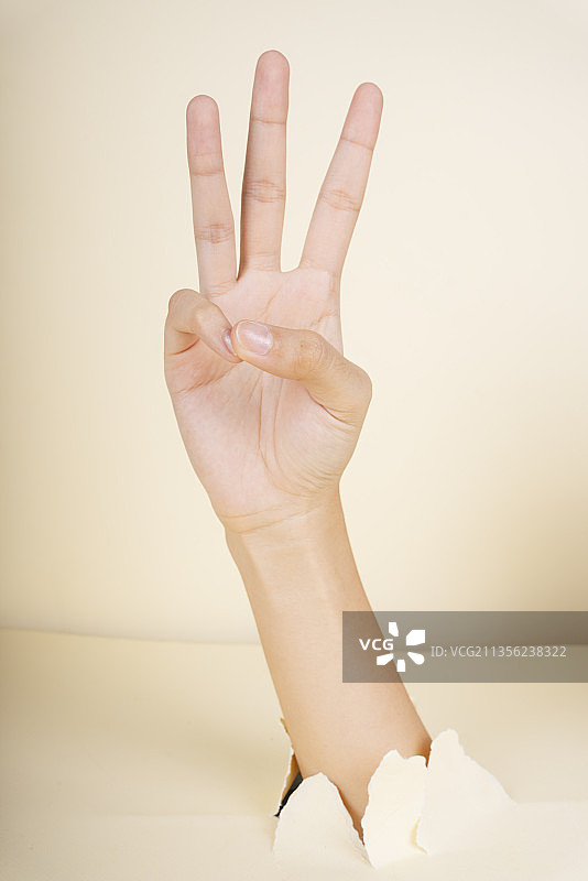 女性手显示3个手指手势孤立在白色背景上。图片素材