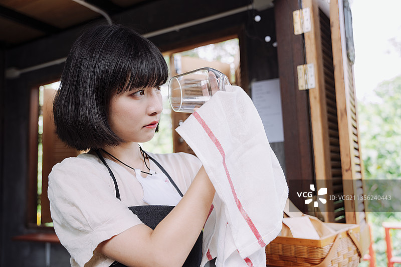 美丽的亚洲泰国女人正在清理酒杯。当地的商业店铺。图片素材