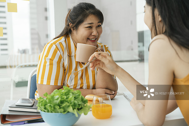 亚洲胖女人喜欢和朋友吃健康的午餐。图片素材