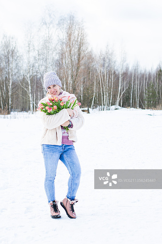 冬天街头手持郁金香的年轻漂亮女孩图片素材