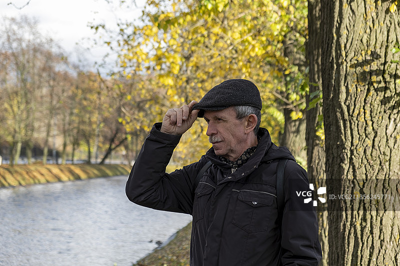 站在森林中树干旁的男人图片素材