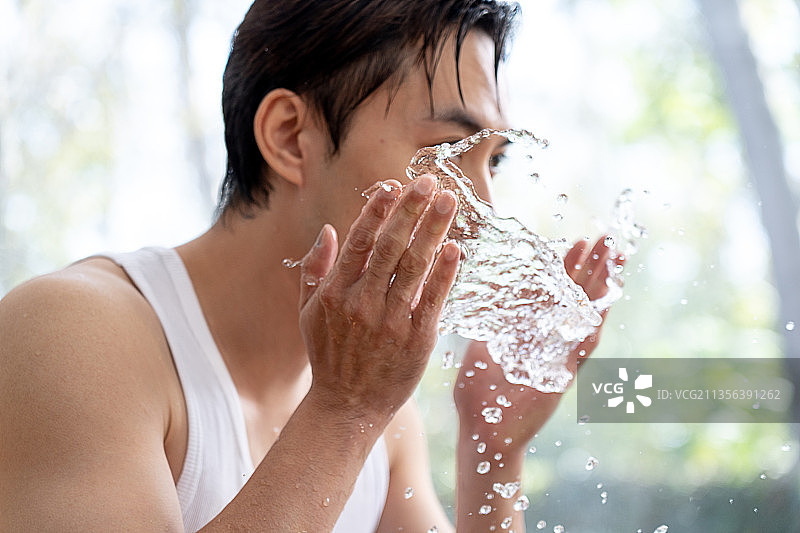 英俊的青年男子在清洁面部图片素材