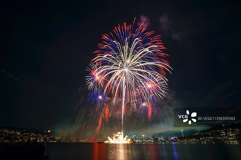 仰视角度拍摄的美国夜空中河流上的烟花图片素材