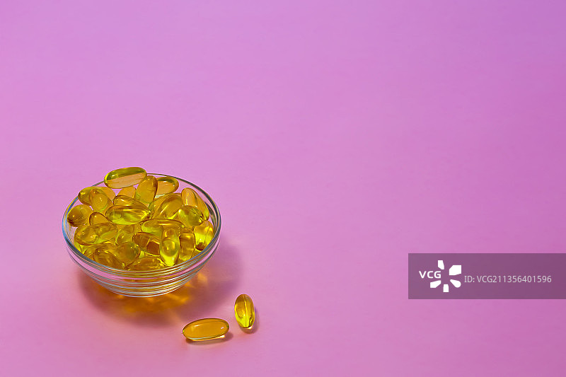粉色背景容器中的药丸特写图片素材