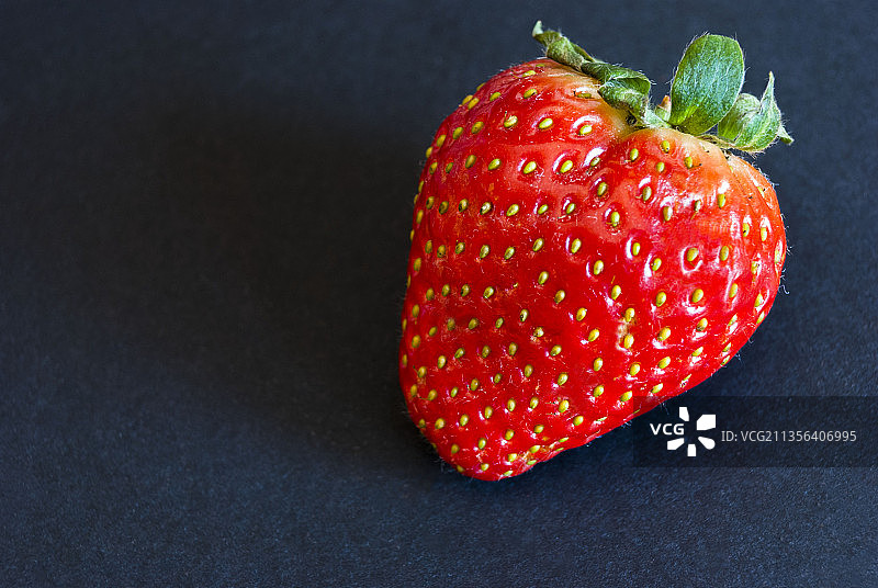 黑色背景上的草莓特写图片素材