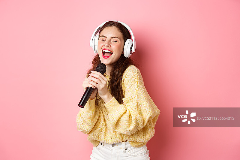 在卡拉OK之夜用麦克风唱歌的女孩图片素材