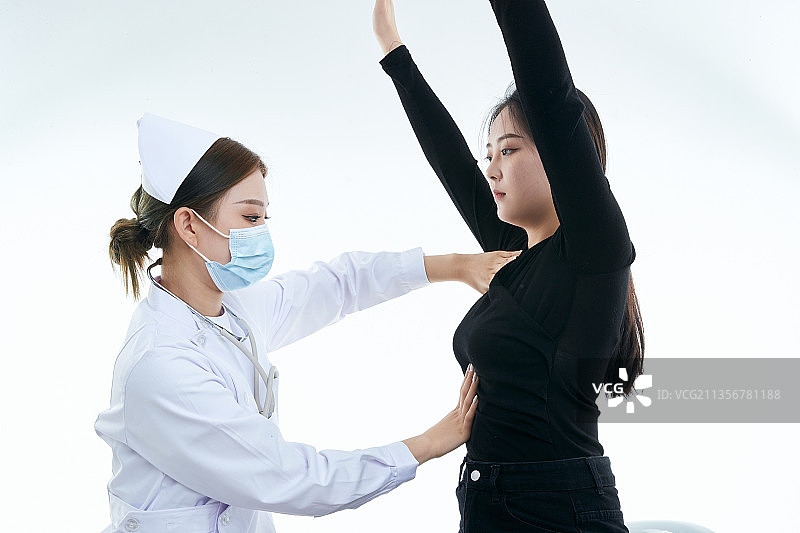 年轻的女性医护人员为患者进行胸部检查图片素材