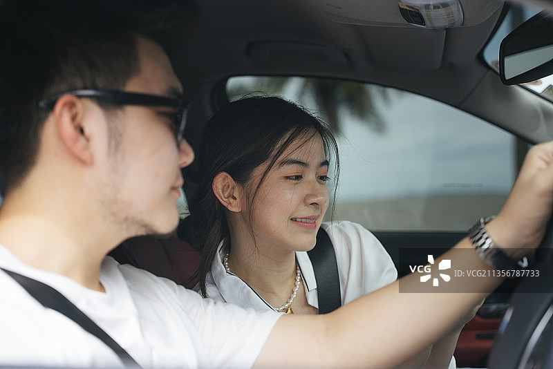 亚洲夫妇旅行者坐在车里进行公路旅行。图片素材