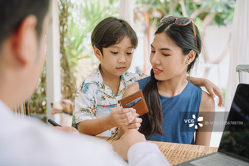 亚洲母子收到卡片后预订了酒店房间。图片素材