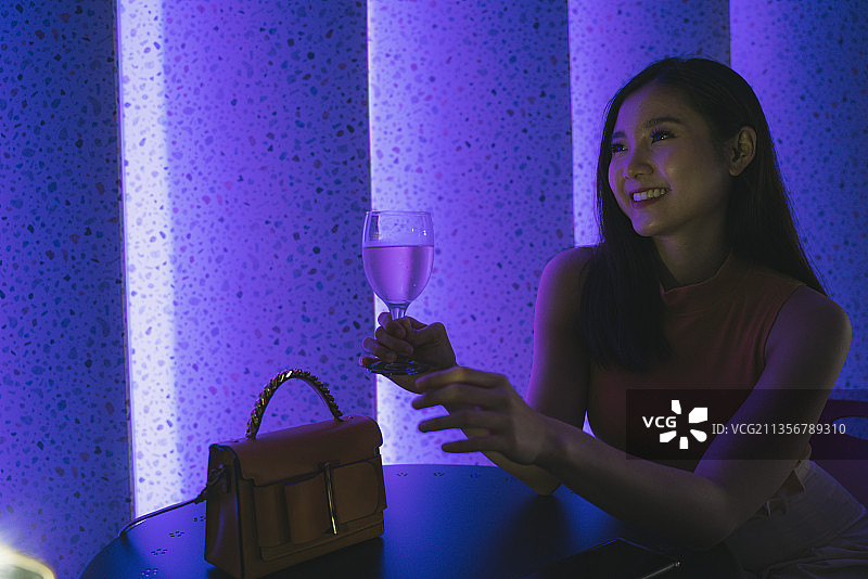 美丽的亚洲泰国女人在夜总会拿着香槟酒。图片素材