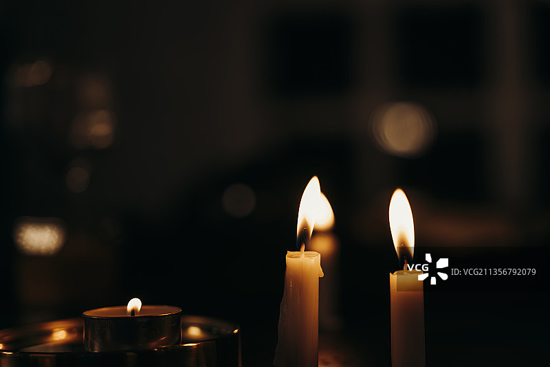晚上黑暗的房间里点着蜡烛。图片素材