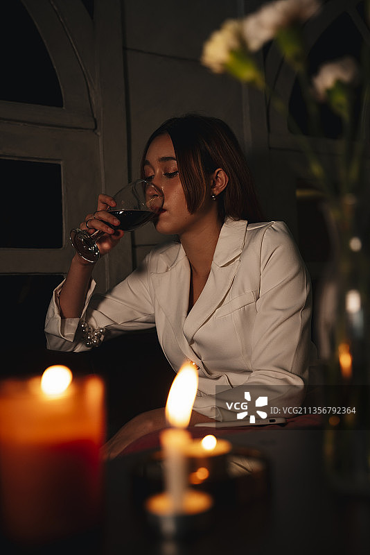 美丽的女商人喜欢在晚上喝红酒。图片素材