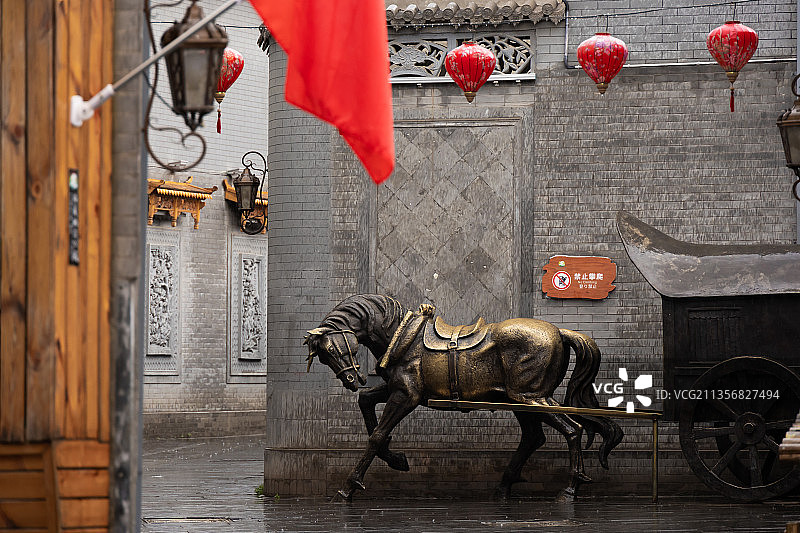 甘肃临夏，八坊十三巷景区，小巷里的铜车马雕塑和红灯笼。图片素材