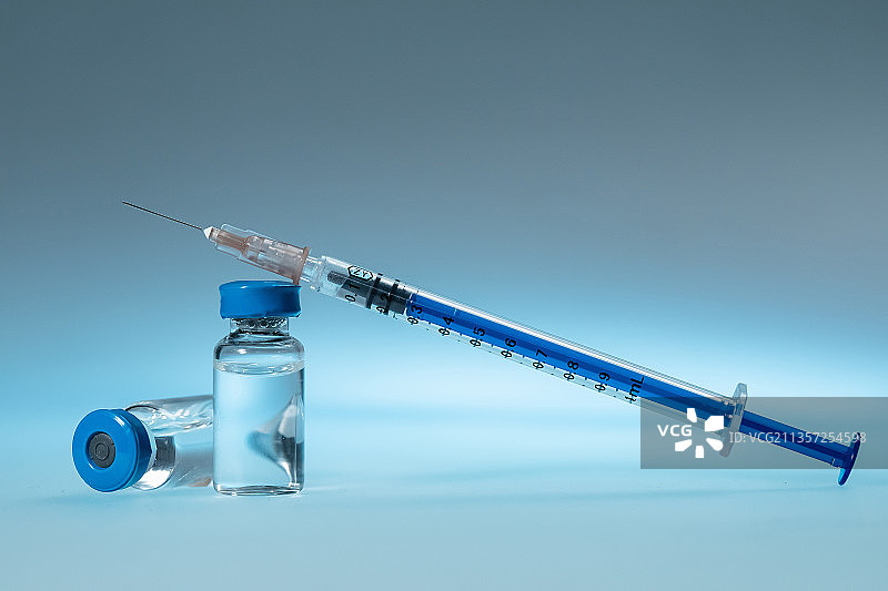 蓝色玻璃药瓶与注射器特写图片素材