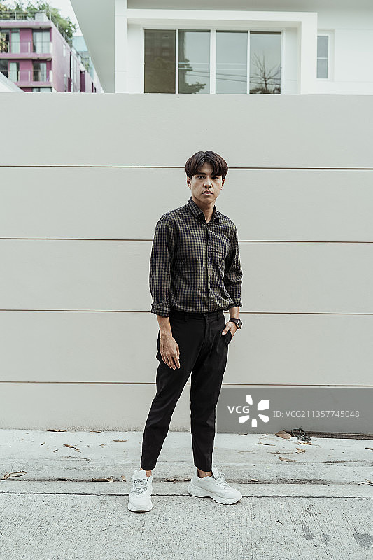很酷的年轻泰国亚洲人穿着正式的黑色衬衫站在街上。图片素材