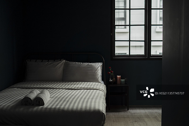 卧室在窗外的光线和床上的两条毛巾。图片素材