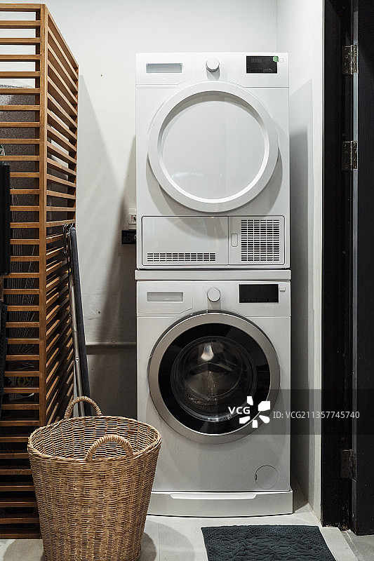 房子里有洗衣机和烘干机，还有木篮子。图片素材