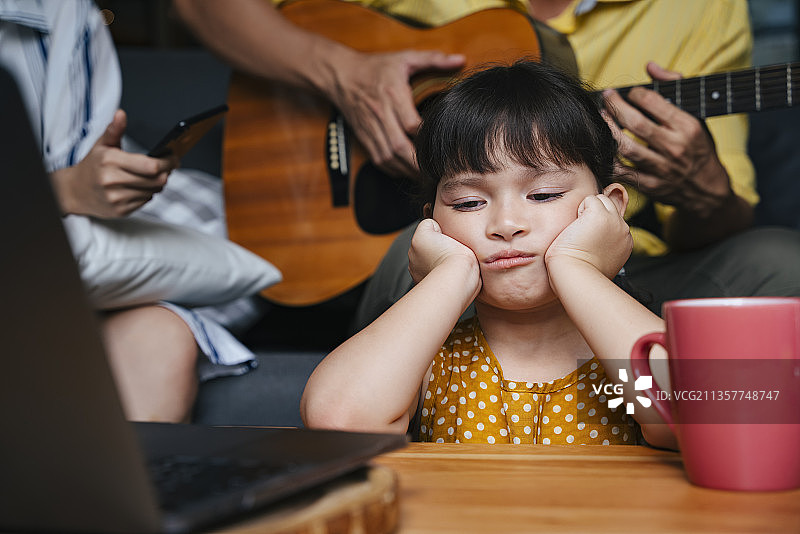 在家里被父母忽视的亚洲小女孩。社会成瘾问题。图片素材