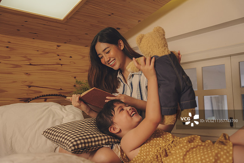 母亲在孩子睡觉前给他讲睡前故事。图片素材