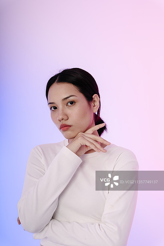 年轻的亚洲女人的肖像在白色长袖在柔和的背景。时尚的概念。图片素材