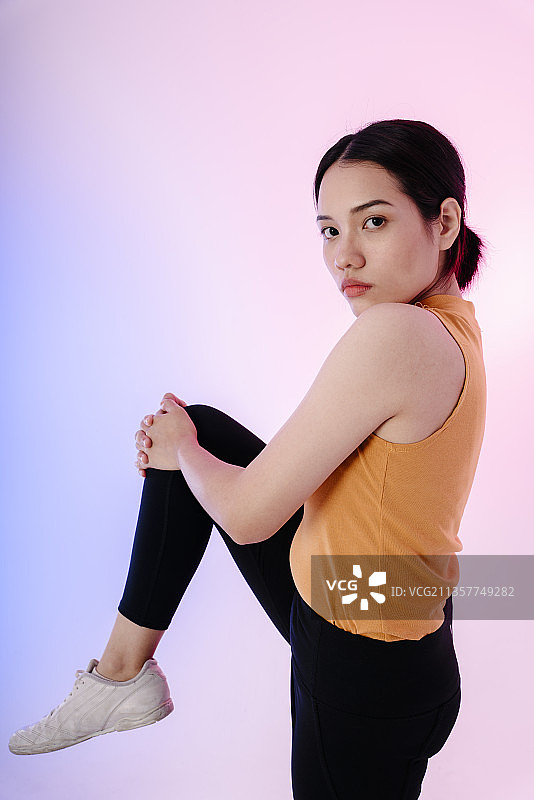 亚洲健康女性运动前伸展腿的肖像。图片素材